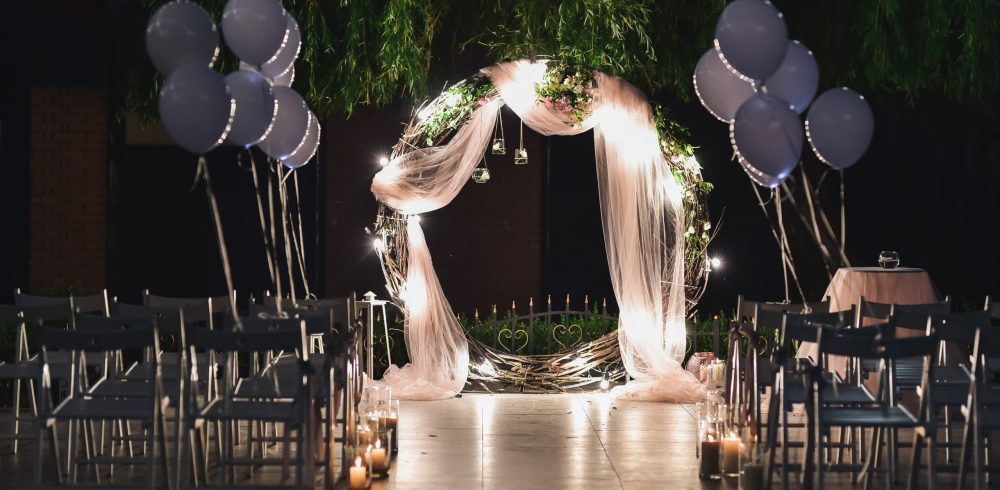 Shine wedding altar for newlyweds stands on the backyard decorated with balloons and greenery